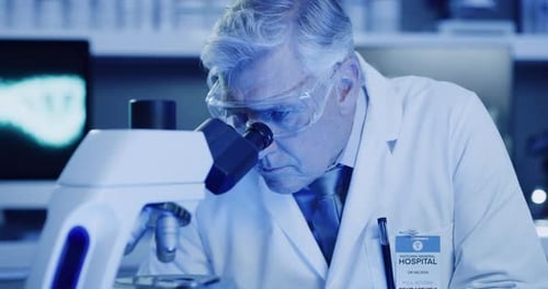 Senior Man Using Microscope in Laboratory