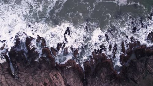 Abstract Top Down Foamy Ocean Waves Crashes Rock