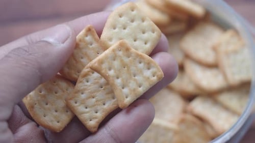 Enjoying Crispy Snacks From a Jar During a Cozy Afternoon