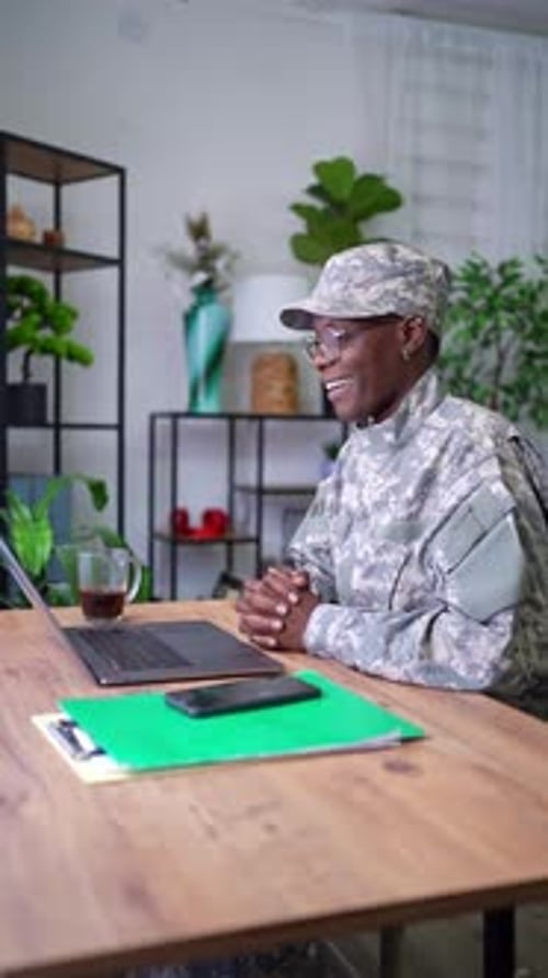 Woman in military uniform video chatting on laptop