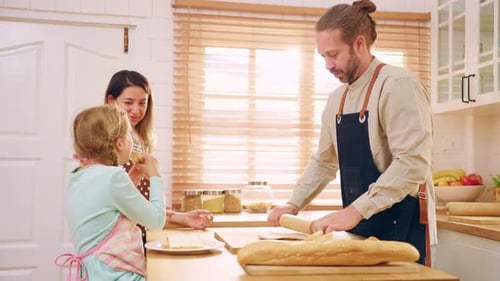 Caucasian young couple baking bakery with daughter in kitchen at home.