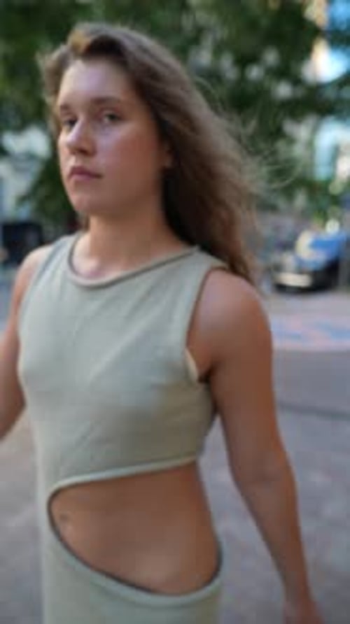 Walking Through the Sundappled Evening City a Girl's Red Curly Hair Adds to Her Allure