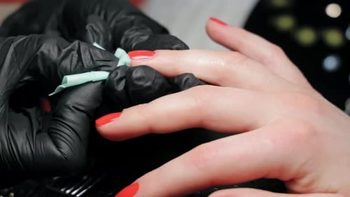 Manicurist Cleaning Bright Orange Painted Nails Close Up