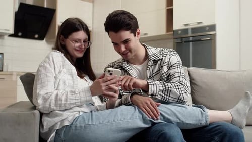 Smiling Couple Using Smartphone at Home Together