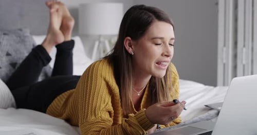 Woman On Bed Using Laptop and Taking Notes