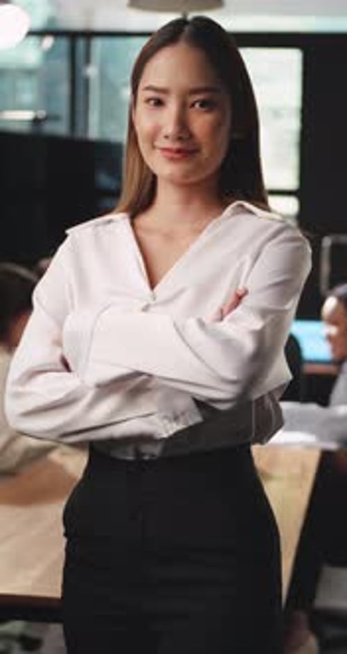 Confident Woman Smiling in Modern Workplace Environment