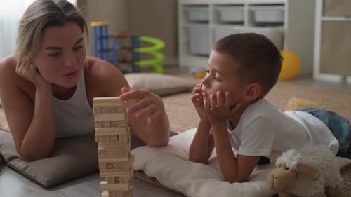 Woman and Boy Play Tower Stacking Game