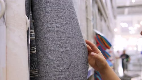 Closeup of a Woman Choosing Wallpaper in a Hardware Store