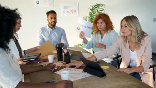 Colleagues Collaborating on Documents in Modern Office