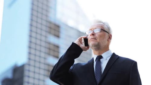 Businessman Talking on Phone in Front of Building