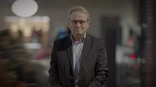 Man in Suit Standing in Urban Crowd