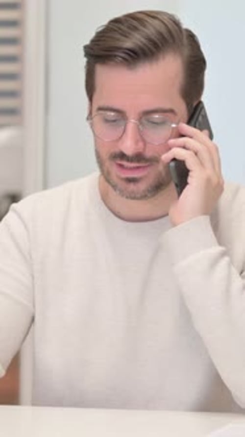 Man with Glasses Talking on Phone Indoors