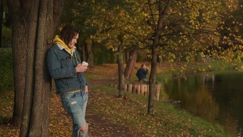 Young Man Leaning by Autumn Lake