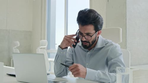 Young Man Talking on Phone at Workplace