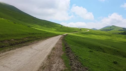 Aerial View of a Beautiful Green Valley and Road in the Mountains