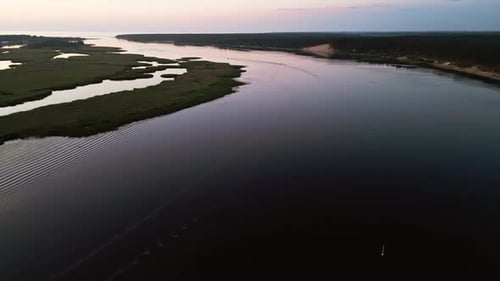 An Aerial View of a Serene River at Sunset Flanked By Lush Green Banks Portraying a Calm and