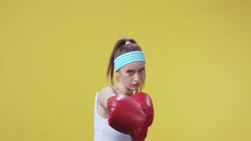 Woman Boxing with Red Gloves on Yellow Background