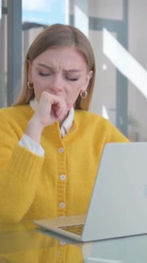 Coughing Young Woman Using Laptop in Office, vertical video