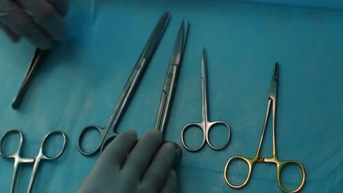 Closeup Top View of Unrecognizable Surgeon Taking Surgical Scissors From Operating Table During