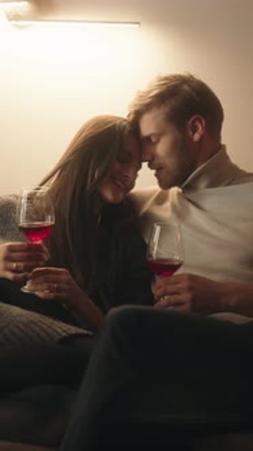 Romantic Couple Sharing Red Wine on a Cozy Evening at Home
