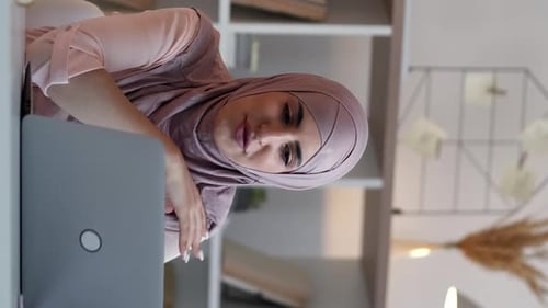 Woman Working on Laptop at Home Wearing Head Covering