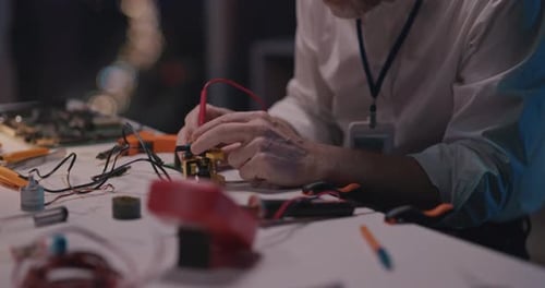 Alter professioneller Mechaniker, bärtiger Rentner, lötet und repariert das Microship-Motherboard beim Bügeln