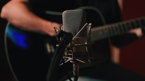 Captivating Acoustic Performance with a Microphone and Guitar Creating Harmonious Music in Studio