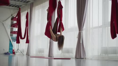 Woman doing aerial yoga in a studio