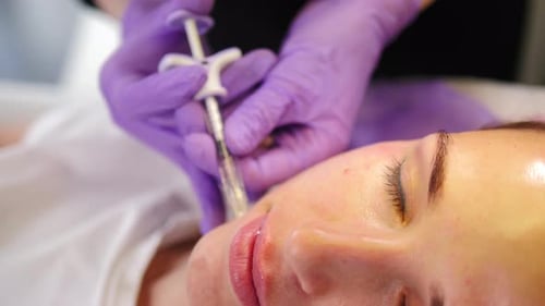 Cosmetologist Performing Facial Treatment on a Woman