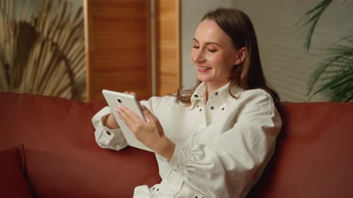 Woman Relaxing at Home Using Tablet
