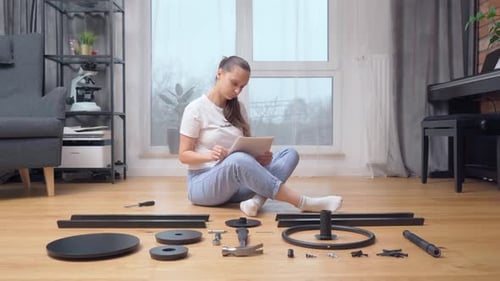 Une femme vérifie un ensemble de pièces de mobilier conformément aux instructions.