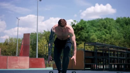 young pumped-up athlete doing push-ups from the ground during street training endurance exercise