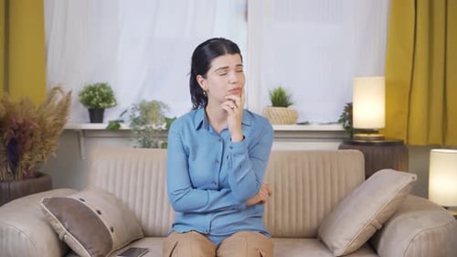 Woman Thinking Sitting on Sofa in Living Room