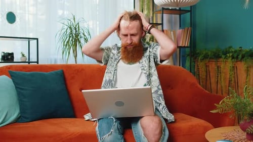 Caucasian Young Man Use Laptop Surprised By Bad News Fortune Loss Fail Lottery Results at Home