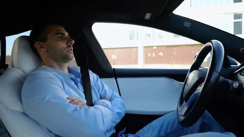 Male Businessperson Experience to Ride an Autonomous Self Driving Electric Car at Urban Road