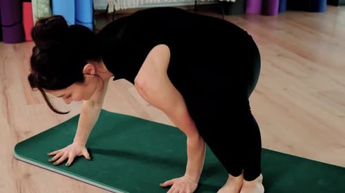 Fitness-Frau trainiert Yoga-Asanas drinnen beim Dehnen des Körpers im Fitnessstudio, Frau tritt auf