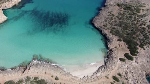 Aerial view of turquoise water and rocky coast in Cala Varques, Mallorca, Spain.