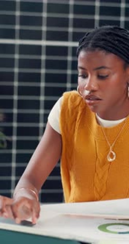 Creative, black woman and document with laptop in office for results, energy saving stats