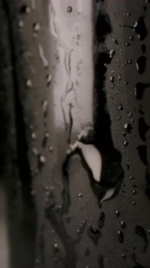 Vertical of Drop of Water Sliding Down Beer Bottle