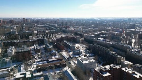 Lots of houses and city buildings at sunny winter day, aerial view.