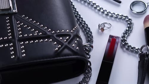 Hintergrund mit trendiger schwarzer Handtasche und dekorativer Kosmetik Nagellack Makeup Pinsel Wimpern oder