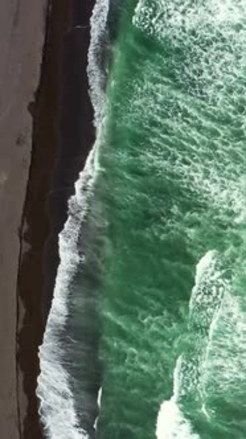 Aerial top view of beach with black sand