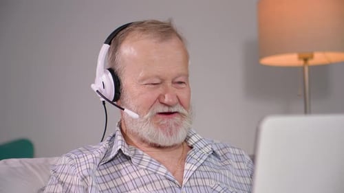 Senior Man with Headset Talking on Computer