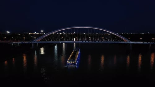 Night aerial shot of a modern Apollo Bridge across river Danube in Bratislava, Slovakia. Drone follo