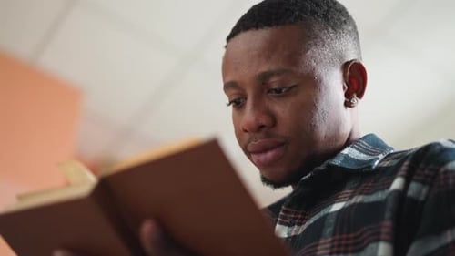 Young Adult Man Reading a Book Close Up