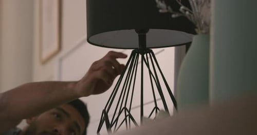 Man turns off bedside lamp, preparing to sleep