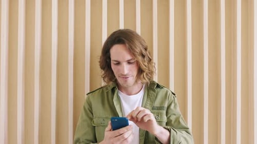 Young Adult Using a Smartphone Indoors