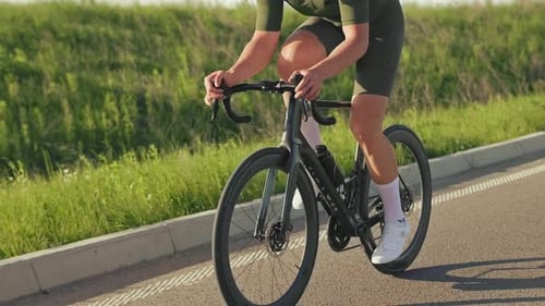 Man Rides Bicycle Along Rural Road