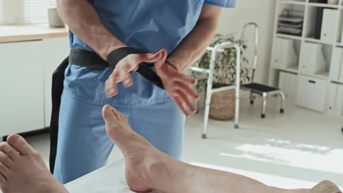 Therapist Adjusting Patient's Ankle with Stretching Strap