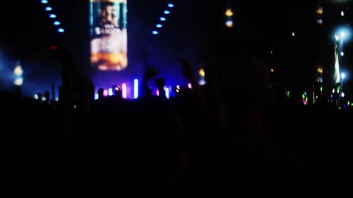 People Jump and Dance at the Evening Concert with Light showFans Raise Their Hands in Front Bright